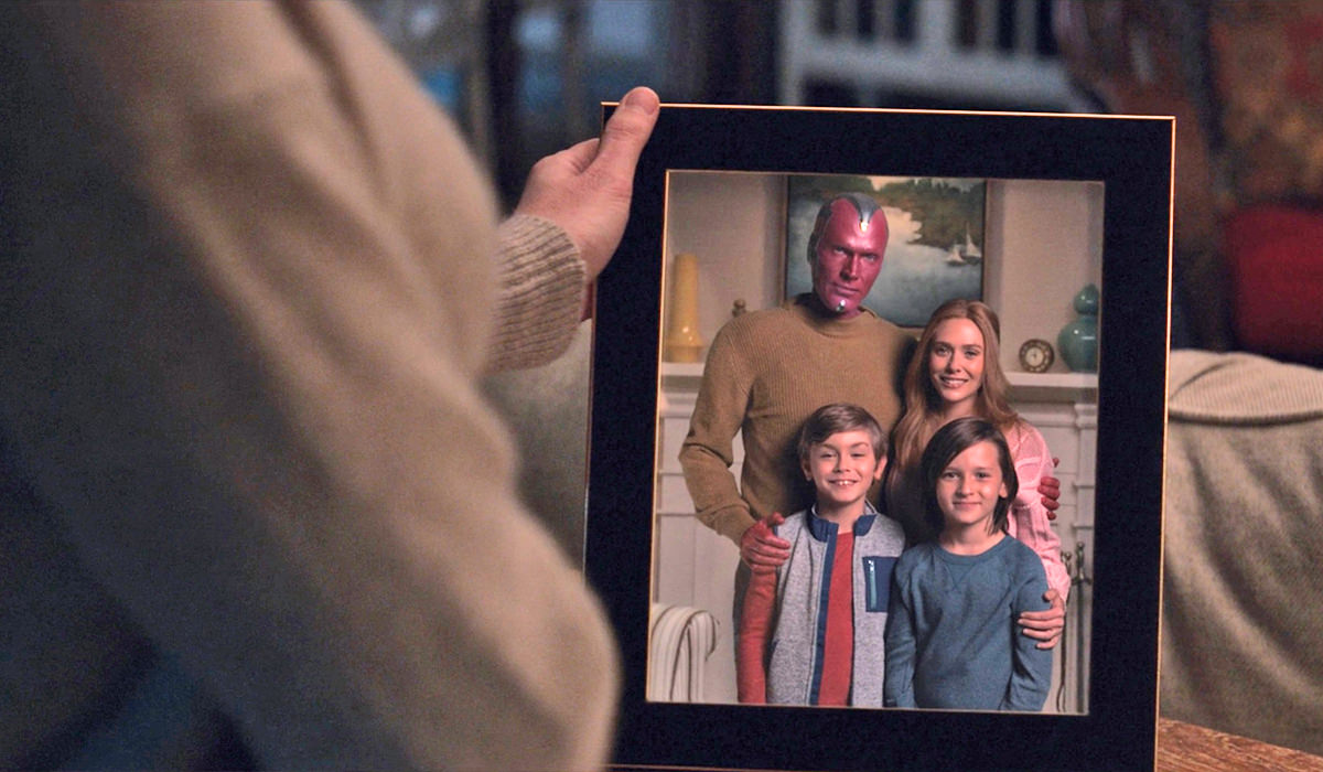 The Vision holding a photo of Wanda's created family.