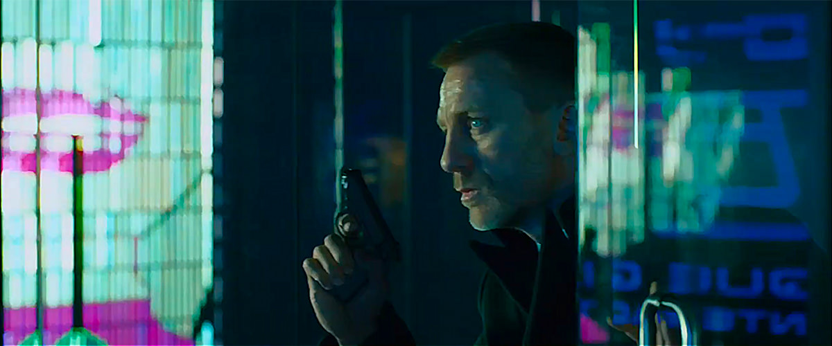 James Bond out to get an assassin with colorful lights and images reflecting on glass walls.