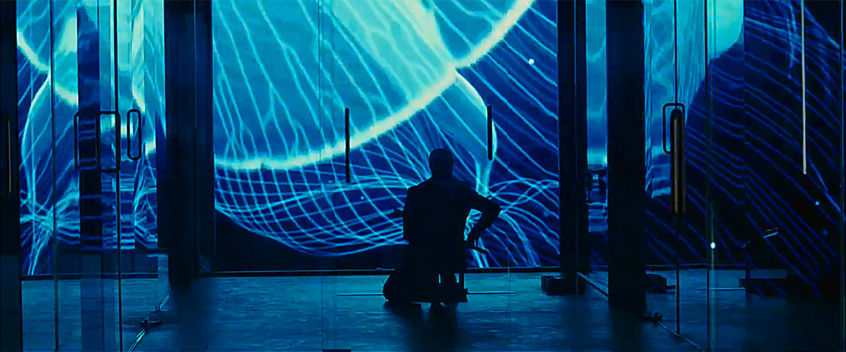 James Bond out to get an assassin with colorful lights and images reflecting on glass walls.